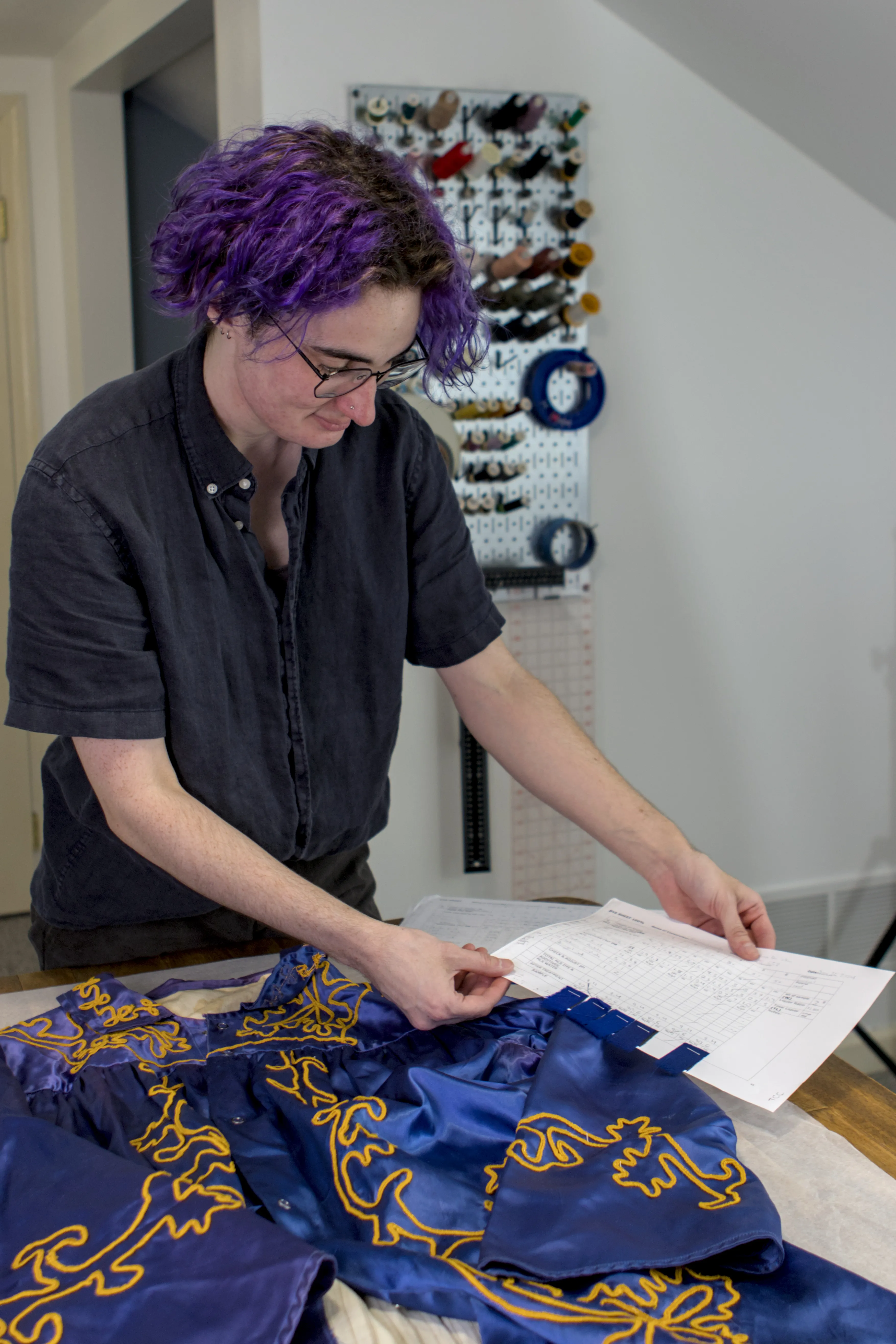 Bryn using a dye sheet to color match a blue and gold robe