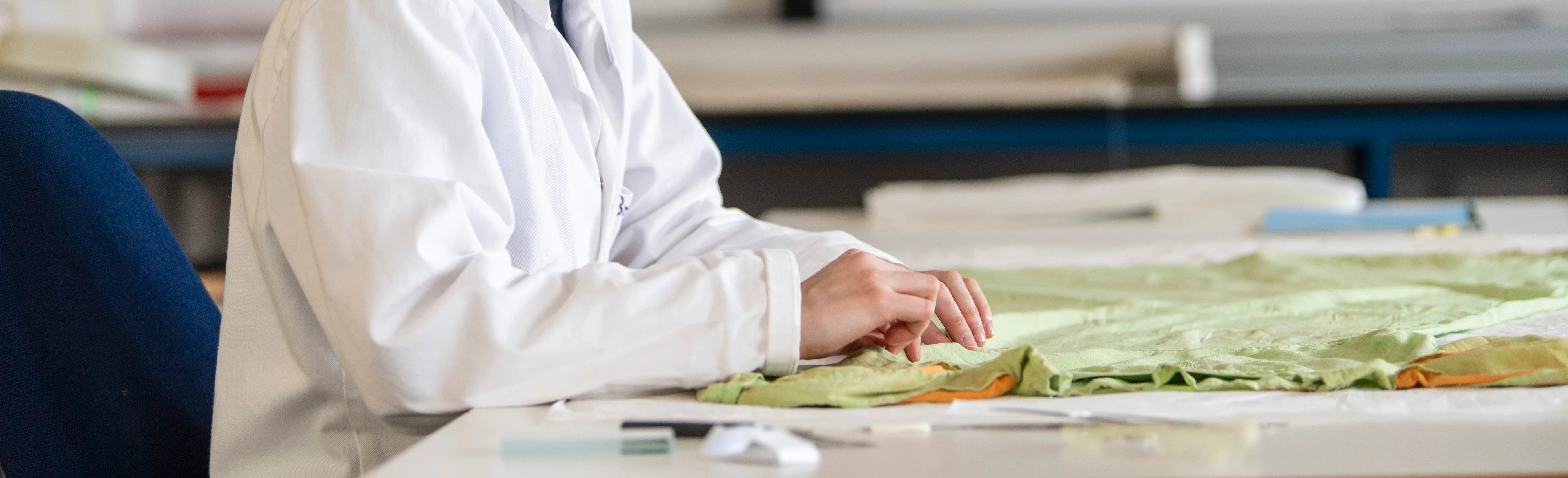 Hands working on textile conservation