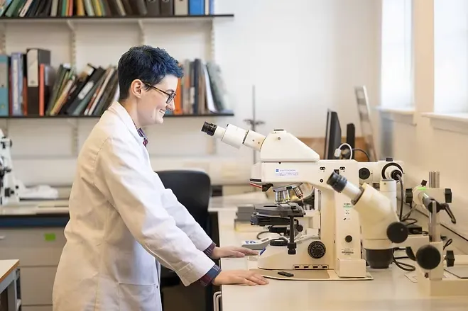 Bryn Kelley working at a microscope. Image courtesy of The University of Glasgow.